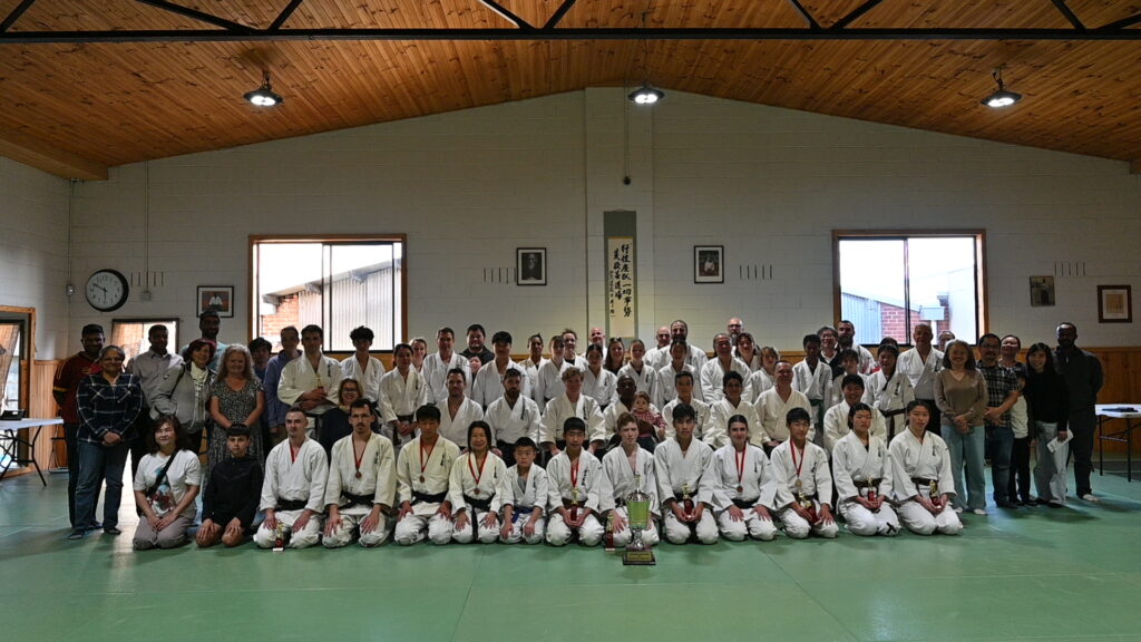 Large group of the Aikido Shudokan community after a demonstration, family, friends and children included.